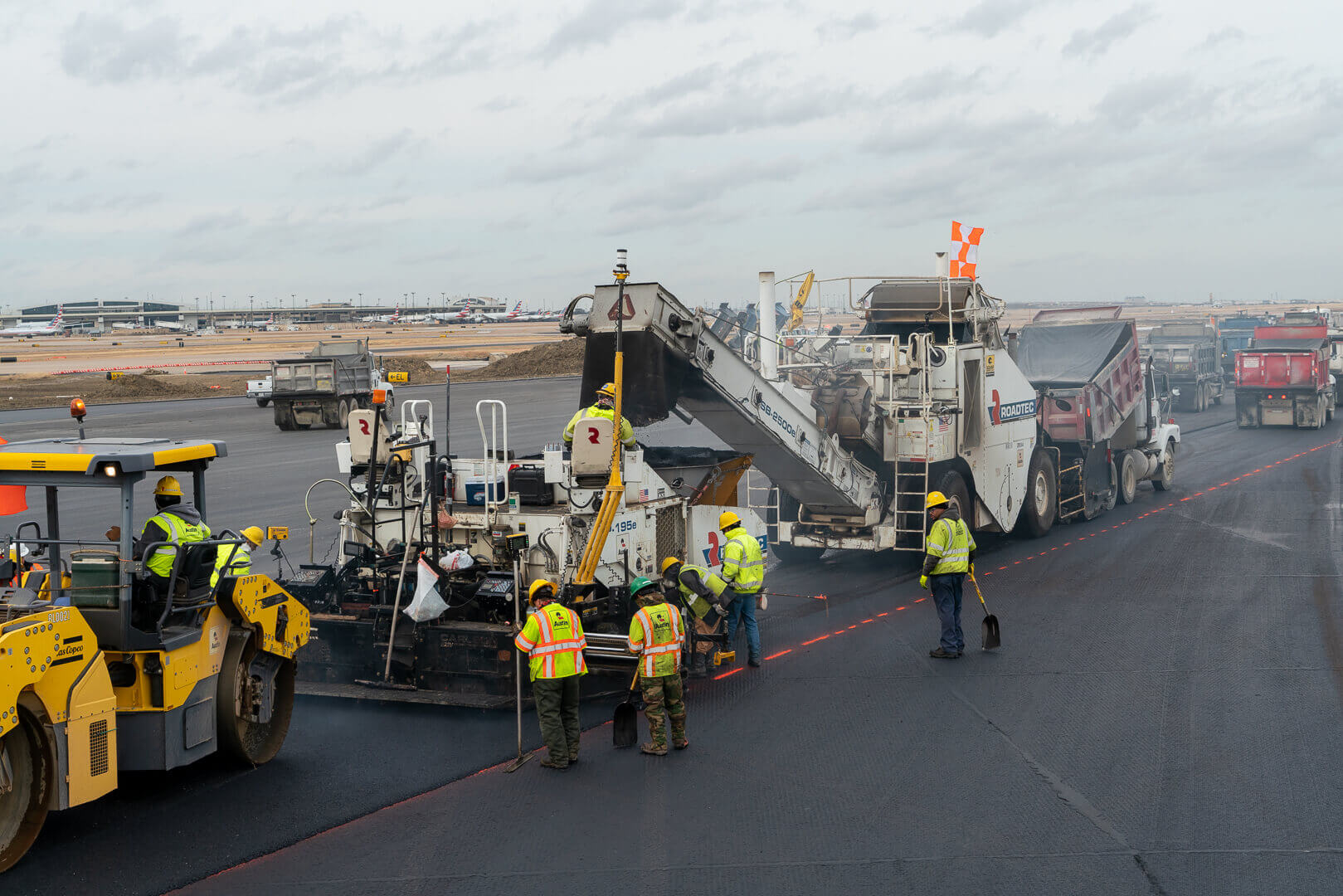 Roadtec RP-190 Highway Class Paver working with a Roadtec SB-2500 Shuttle Buggy Material Transfer Vehicle at DFW airport