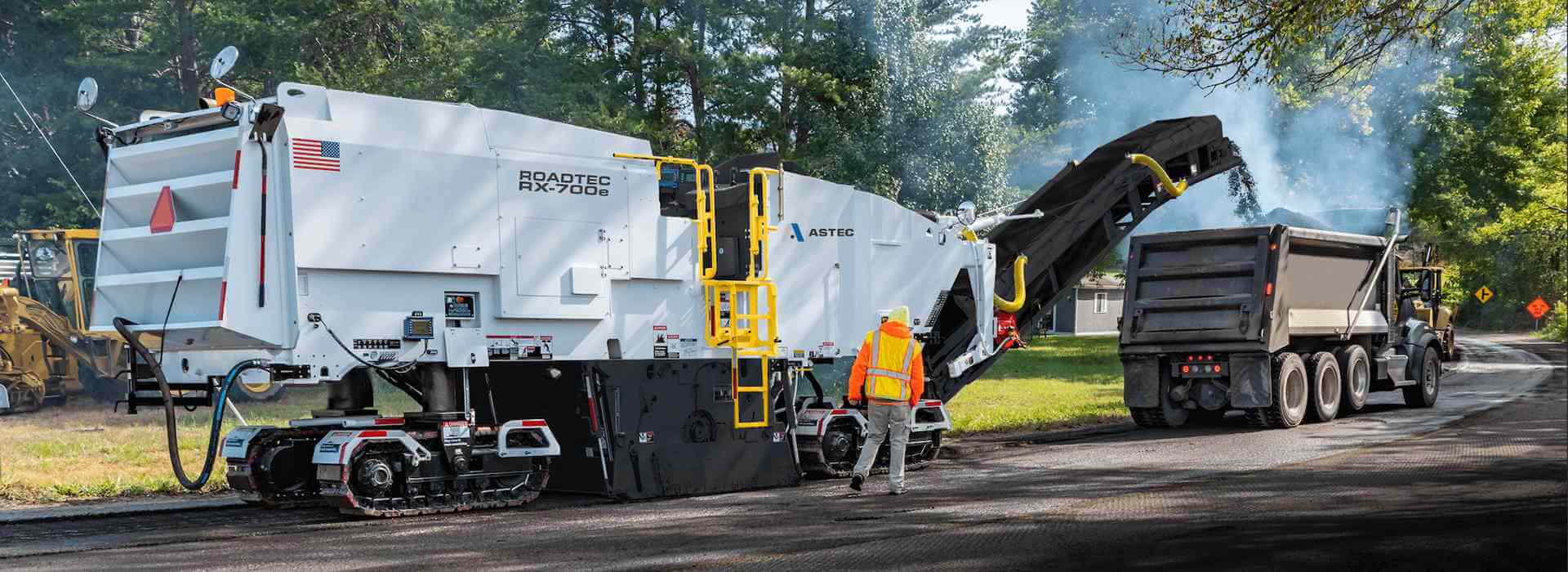 Roadtec RX-700 cold planer milling asphalt off the road surface into a dump truck