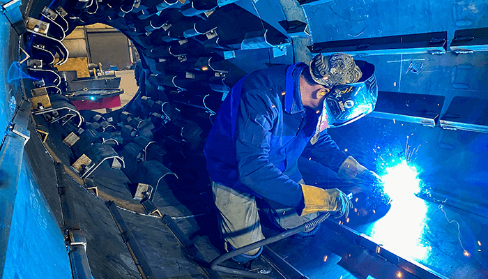 Welder-In-Drum_Small Welder inside of an asphalt drum welding flights