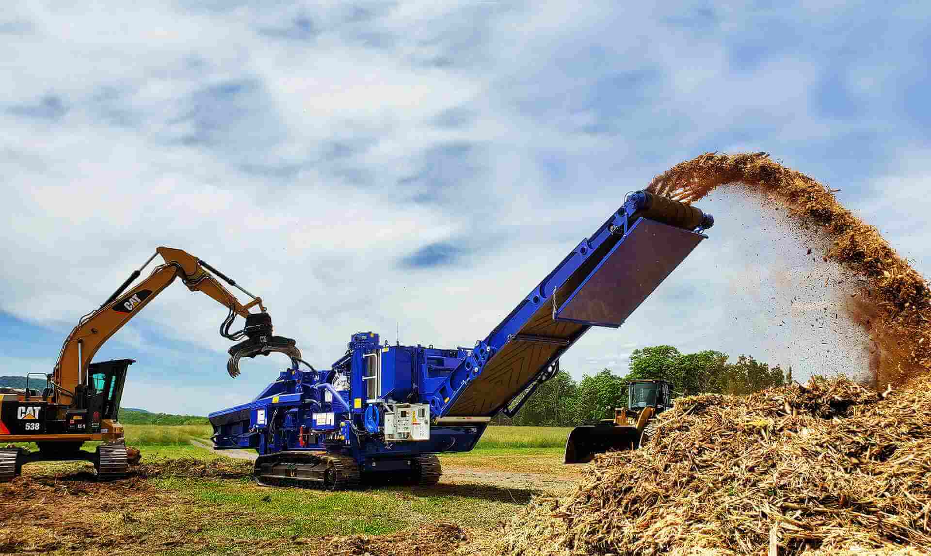 Astec Peterson 5710D Horizontal Grinder making biomass in Pennsylvania with a grapple loading excavator.